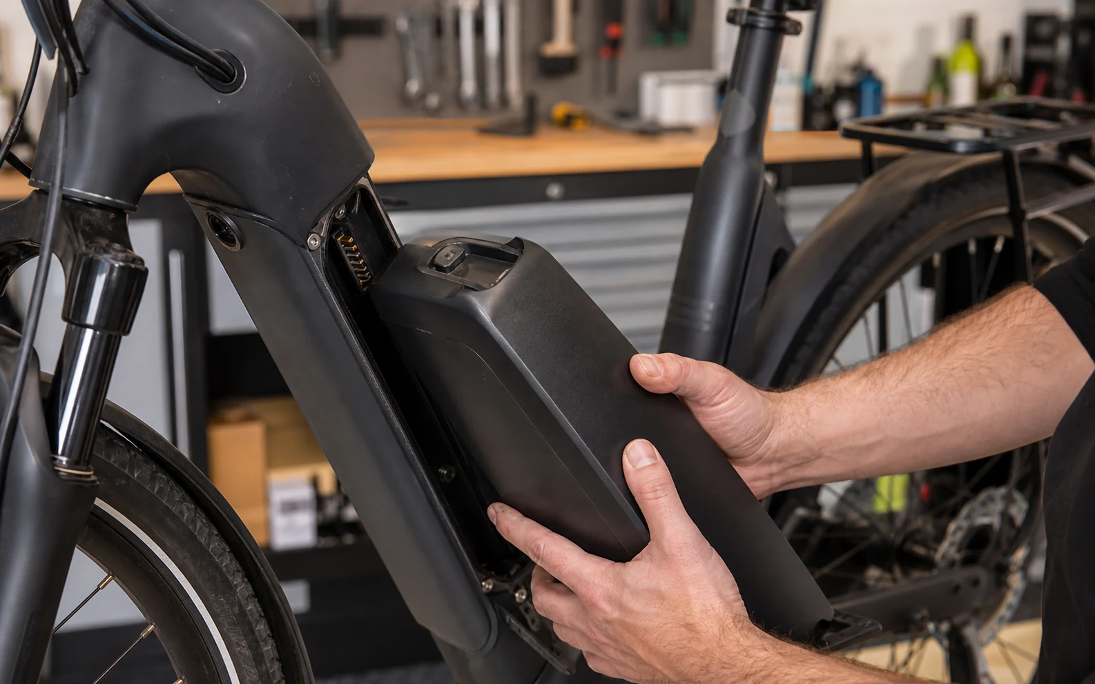 Professional workshop reviewing an e-bike battery, housing and charger
